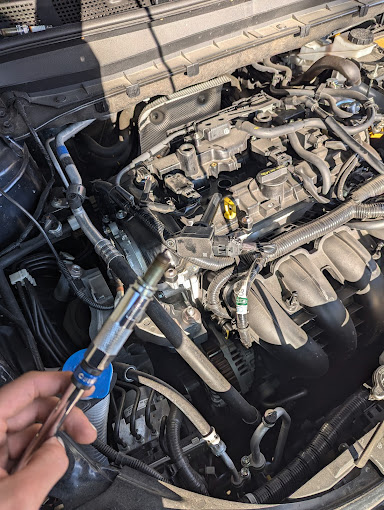 A man is working on the engine of a car