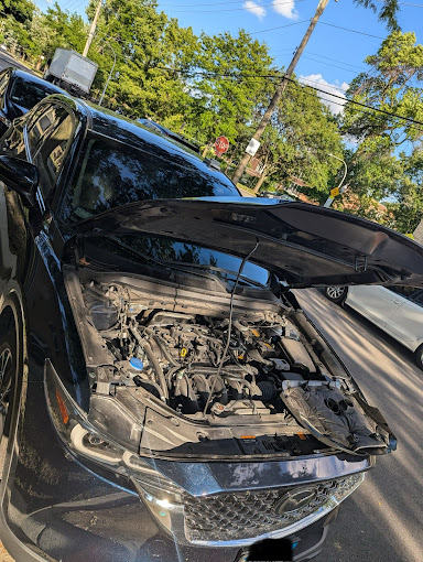 A car with its hood open on the street